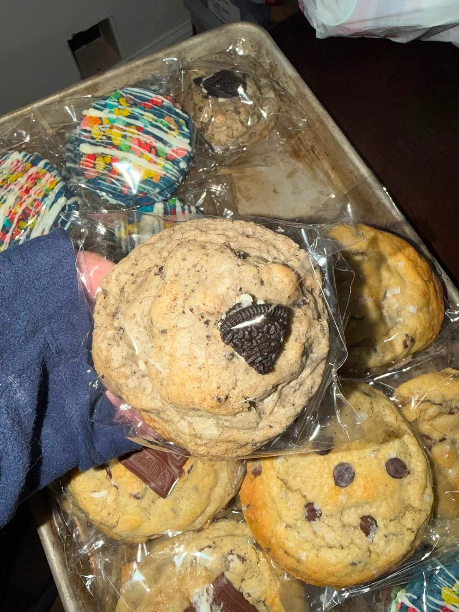 Cookie topped with an Oreo alongside a tray of assorted cookies